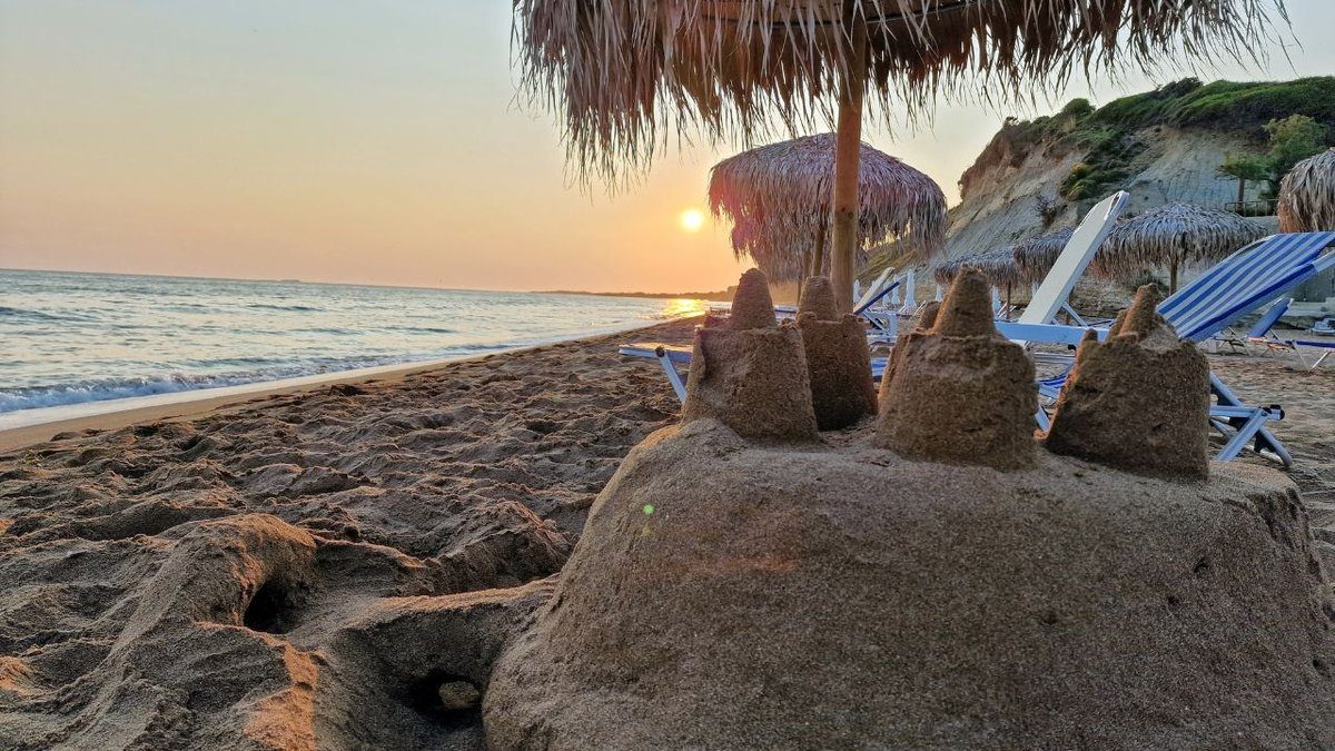 a beach in corfu at sunset